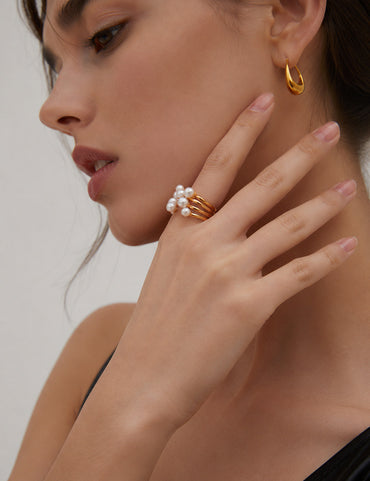 A professional studio shot of the Sia open ring in Vintage Gold, highlighting the warm 18K plating and the satiny luster of the central natural pearl.