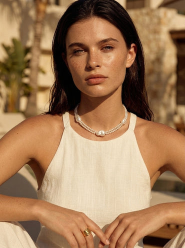 Model wearing Vera Lustre Selene double-strand baroque pearl necklace in 18K gold vermeil, styled for a luxury Mediterranean look.