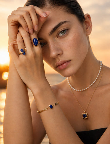 A lifestyle shot of the Cyra gemstone bracelet on a wrist, showcasing the mesmerizing golden bands of Tiger's Eye and the royal blue of Lapis Lazuli against a chic blazer.