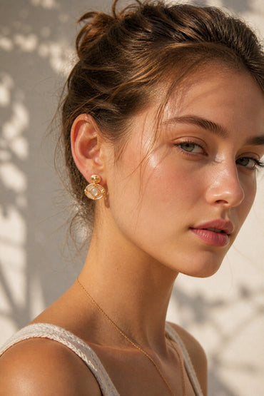 A lifestyle shot of the Artemis green chalcedony studs worn by a model. The visual highlights the intricate golden frame and how the verdant gemstone adds a luxurious, vintage-inspired focal point to the ear.