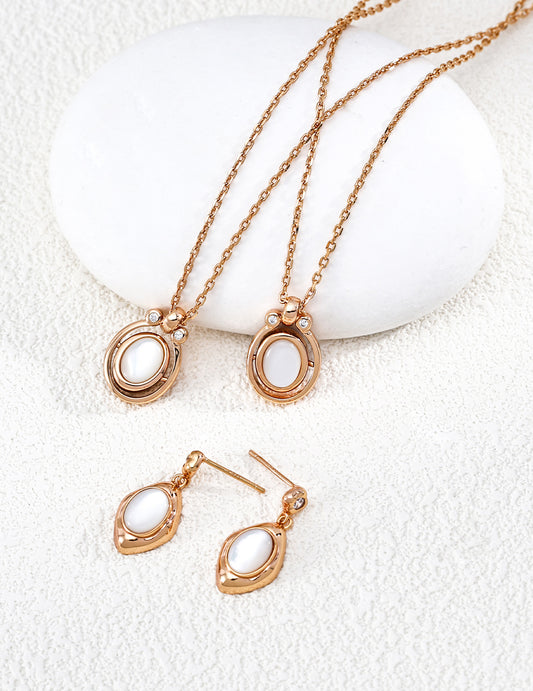 A crisp display of the Astra Mother of Pearl jewelry set, featuring the iridescent white shell inlay in both the necklace and matching pieces. The soft glow of the natural white shell is contrasted by a halo of sparkling cubic zirconia, emphasizing the premium S925 sterling silver craftsmanship and a clean, luxury aesthetic.