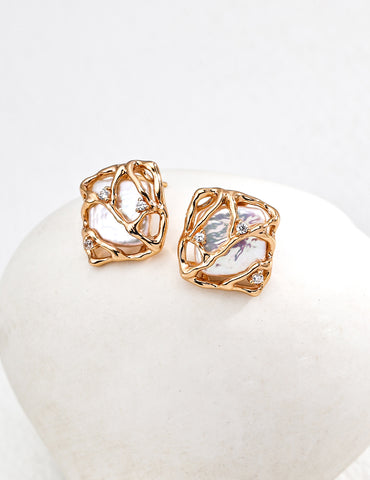 Vera Lustre "Gaia" stud earrings featuring unique baroque pearls encased in an intricate 18K gold vermeil woven cage design.