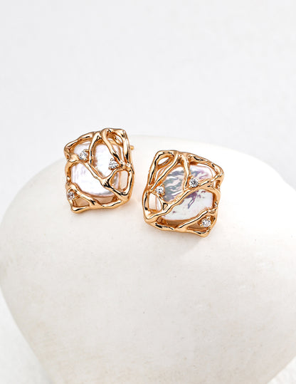 Vera Lustre "Gaia" stud earrings featuring unique baroque pearls encased in an intricate 18K gold vermeil woven cage design.