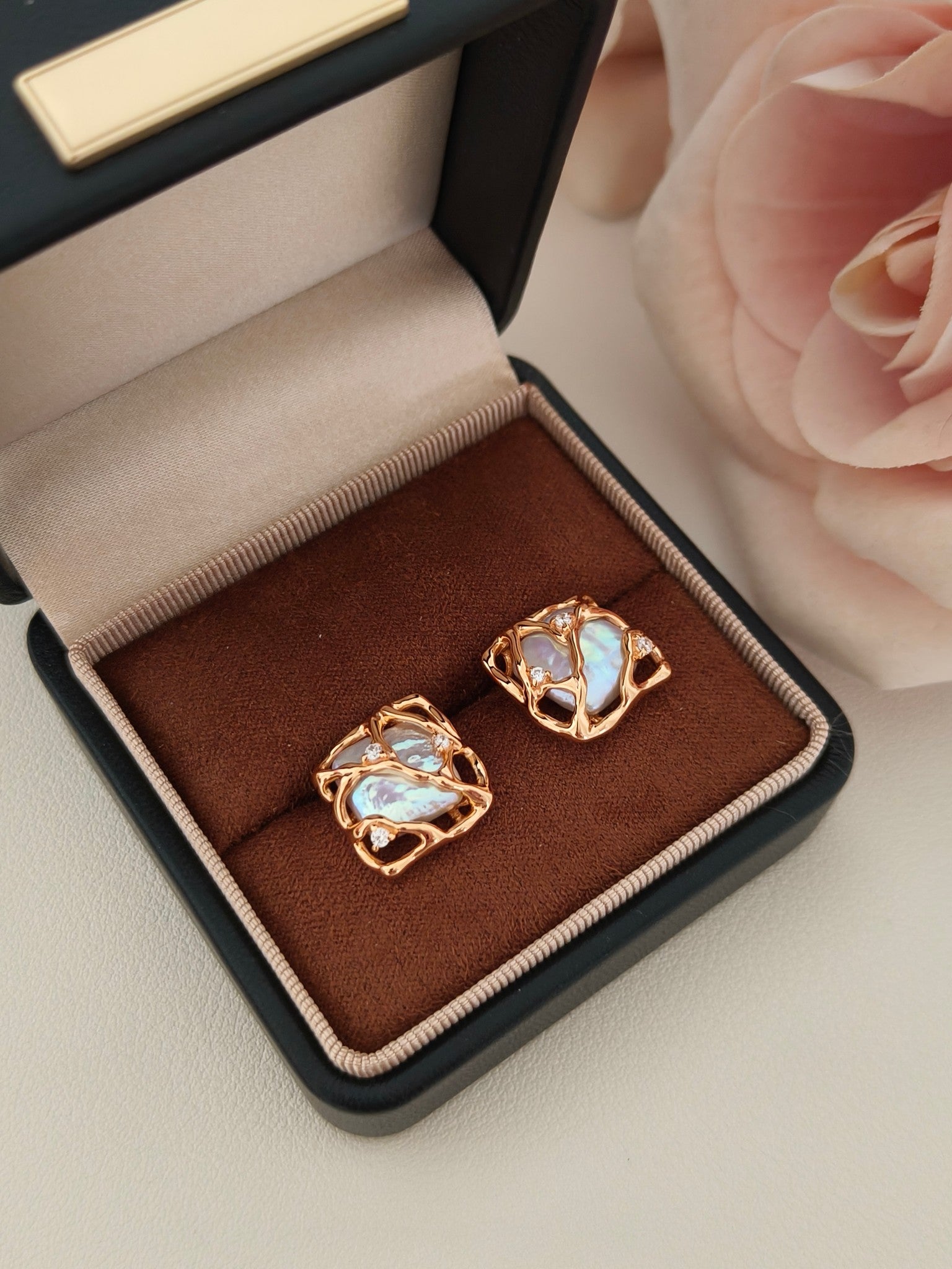 Vera Lustre Gaia earrings presented in a premium gift-ready box, emphasizing the contrast between the iridescent pearl and the radiant gold cage.
