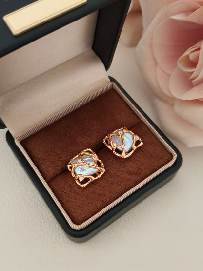 Vera Lustre Gaia earrings presented in a premium gift-ready box, emphasizing the contrast between the iridescent pearl and the radiant gold cage.