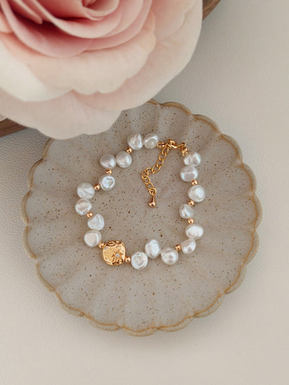 An overhead view of the bracelet laid flat, illustrating the rhythmic arrangement of the pearls and the flexibility of the link chain design.