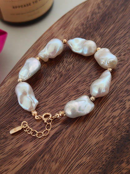 Close-up of the luminous freshwater pearls and the Vera Lustre quality seal on the 18K gold vermeil extender chain.