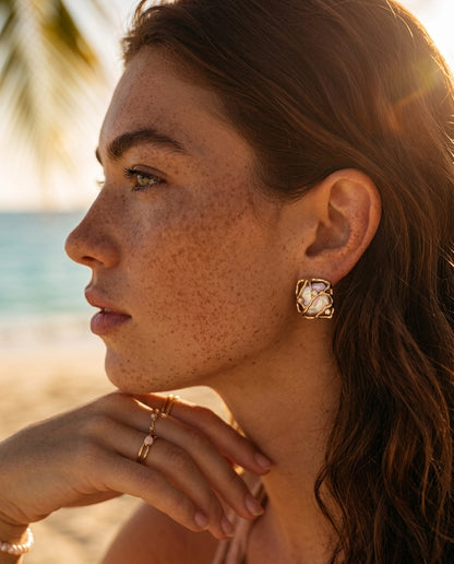 A lifestyle image of a woman wearing the Gaia woven pearl earrings, highlighting their architectural beauty and sophisticated "Quiet Luxury" 