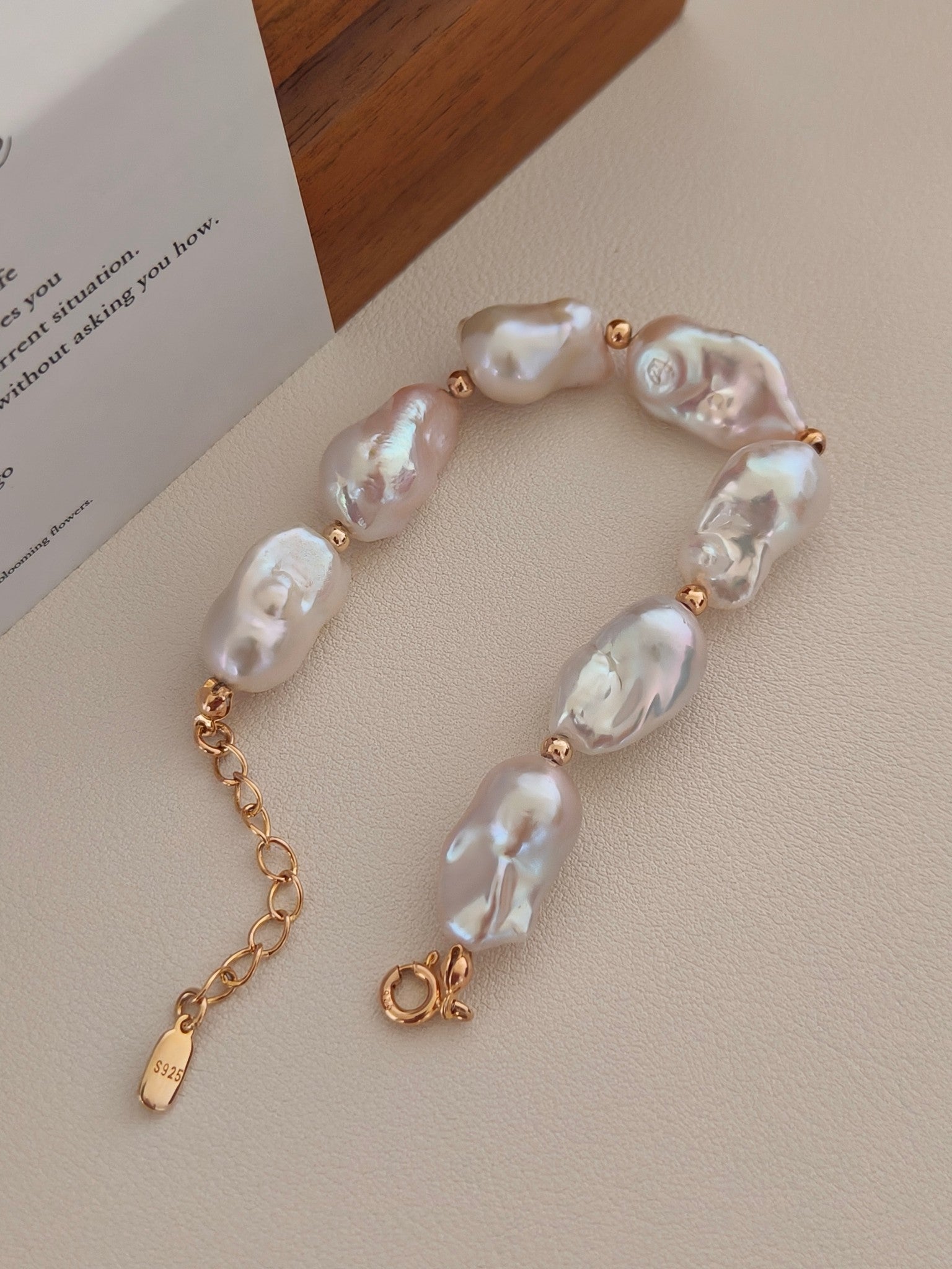 The Vera Lustre Luna bracelet displayed on a professional jewelry card, showcasing the high-luster and iridescent finish of each unique pearl.