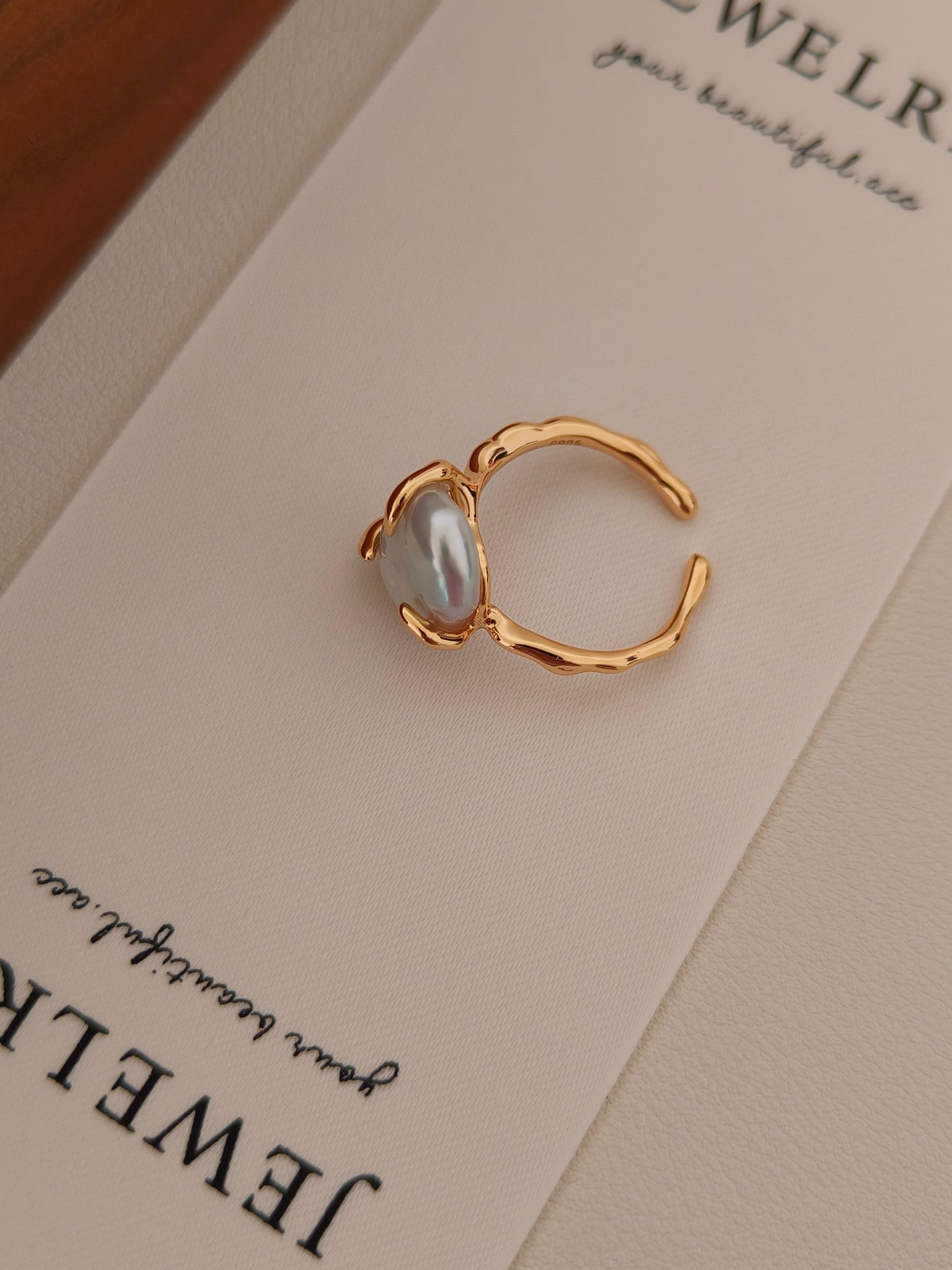 Close-up of the Aura organic pearl ring on a Vera Lustre jewelry card, highlighting the natural luster and textured gold band.