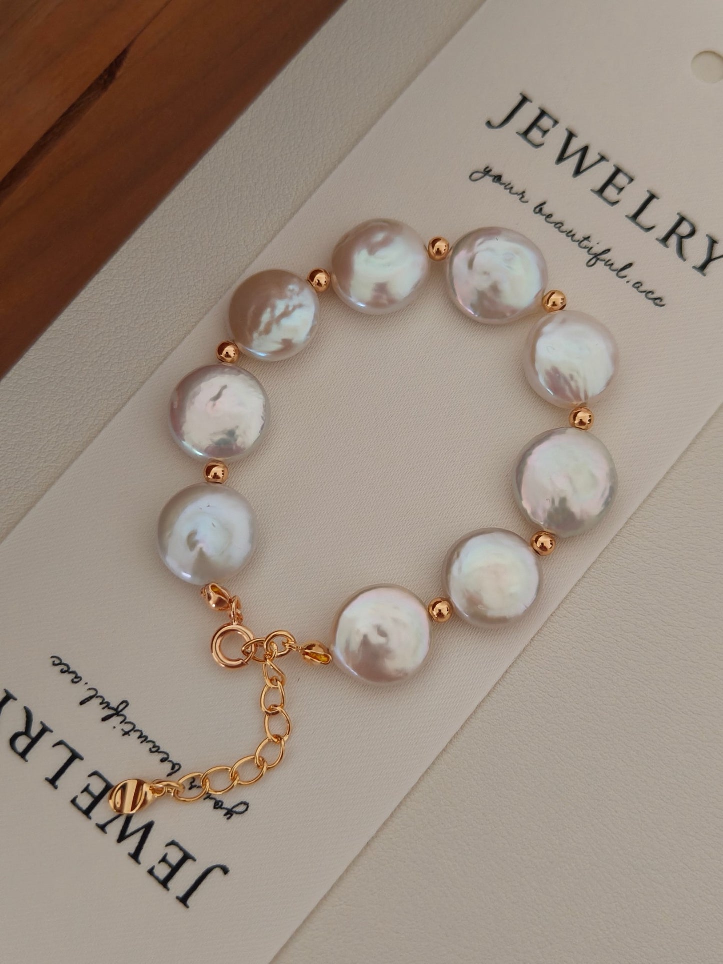 The Selene flat baroque pearl bracelet displayed on a Vera Lustre jewelry card, emphasizing the unique organic shapes of the coin pearls.