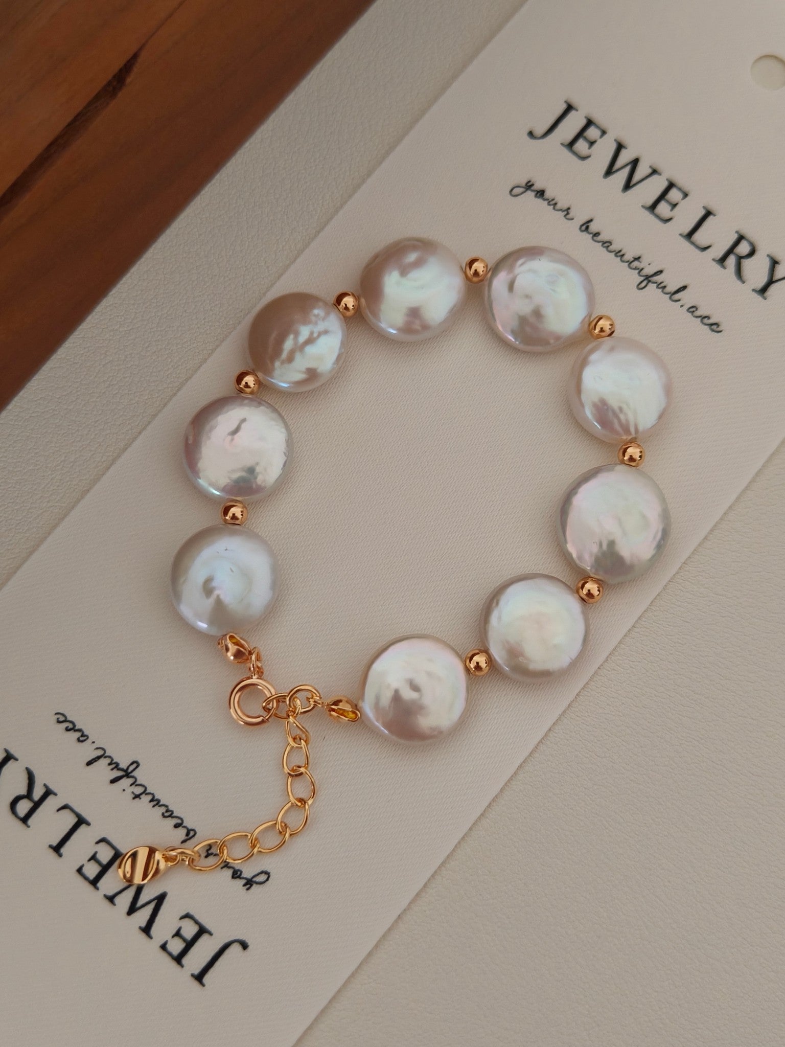 The Selene flat baroque pearl bracelet displayed on a Vera Lustre jewelry card, emphasizing the unique organic shapes of the coin pearls.