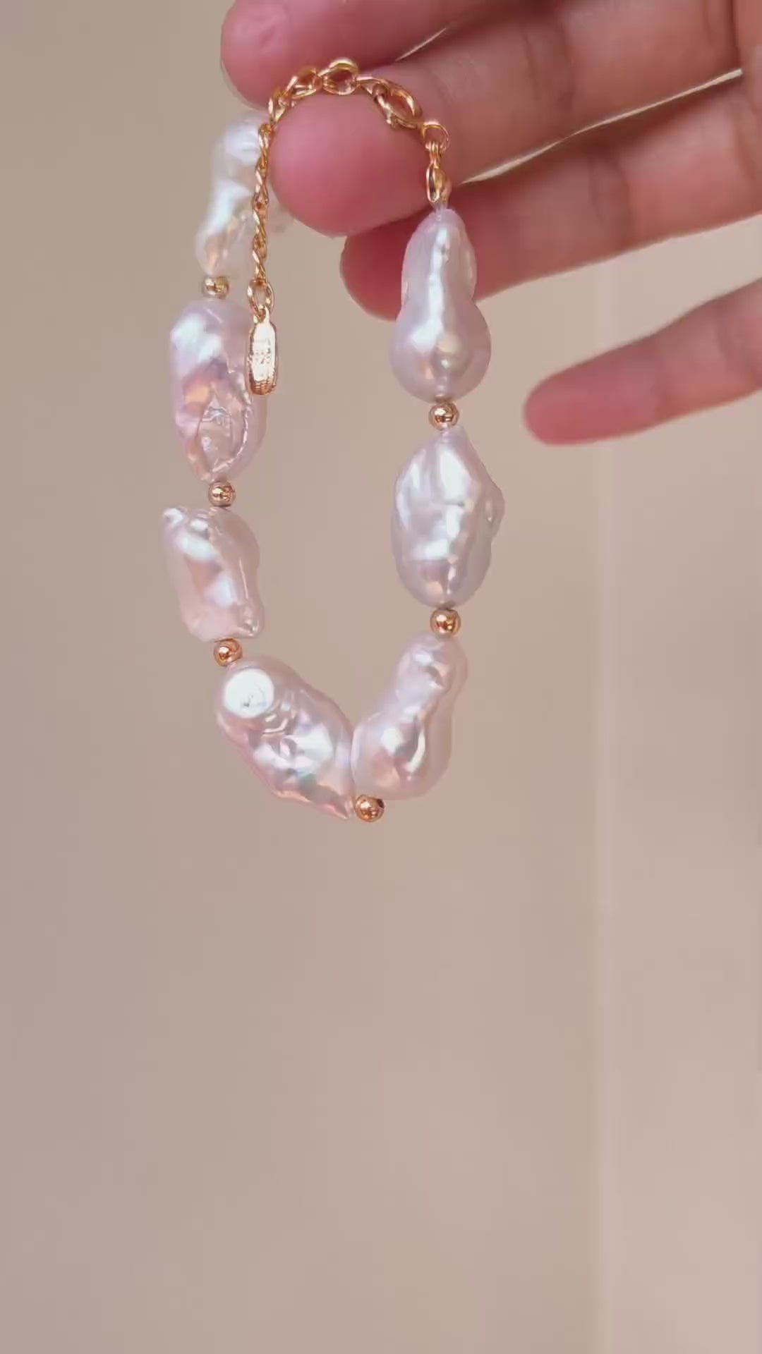 A detailed view of the Luna organic pearl bracelet, demonstrating the movement and radiant glow of the hand-selected baroque pearls.