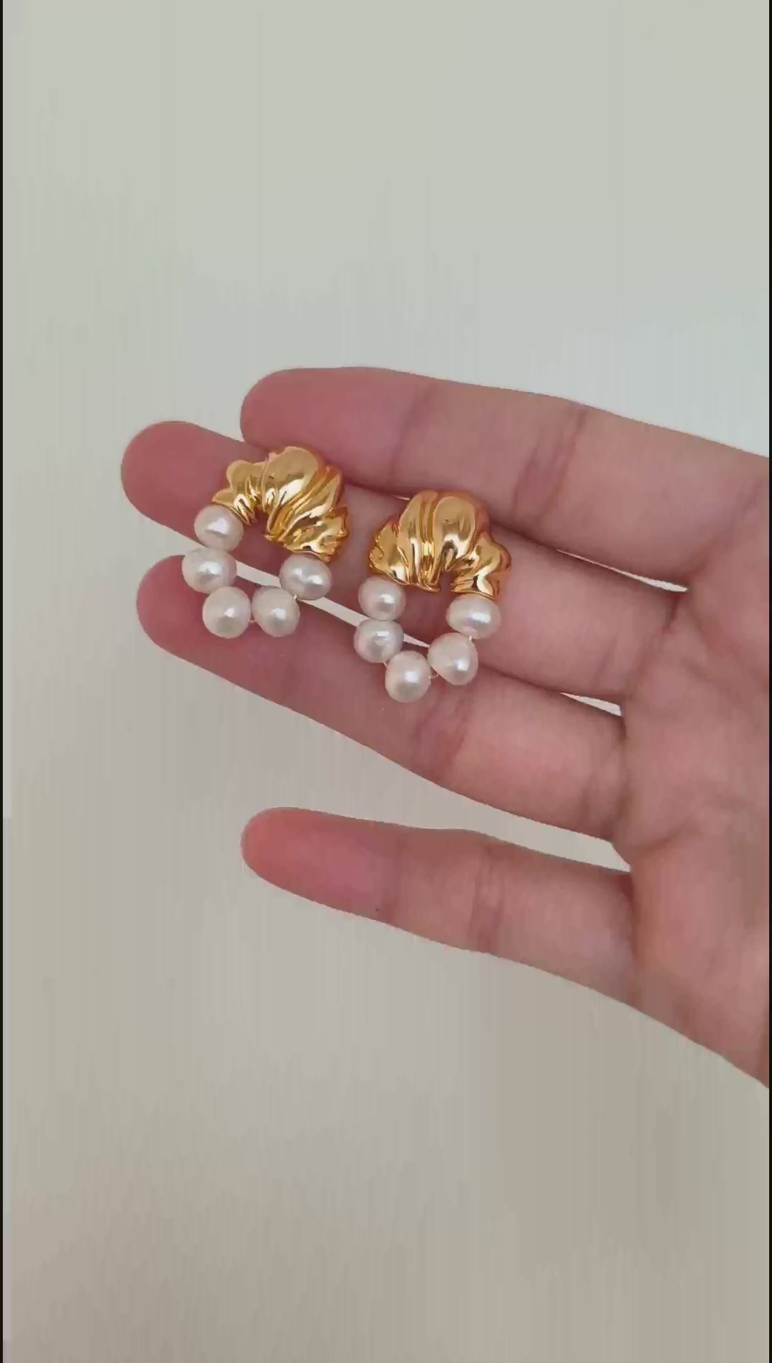 A cinematic video of the Eos earrings in motion. As they sway, the video captures the shifting "orient" of the baroque pearls and the brilliant reflection of the golden hardware, demonstrating their dynamic elegance.