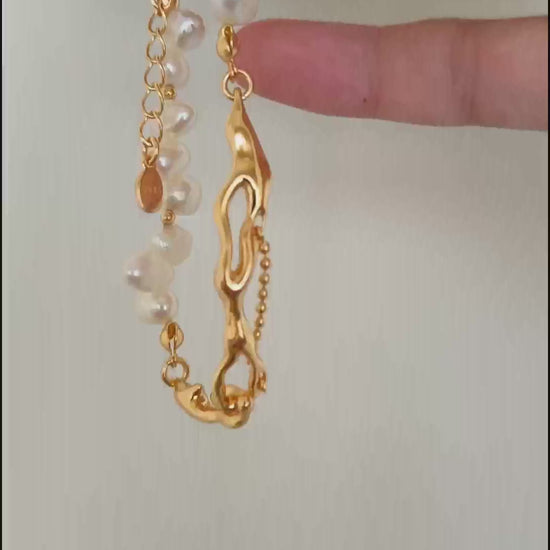 A cinematic video of the Astraea bracelet shimmering under natural light, capturing the iridescent depth of the pearls and the liquid-like movement of the gold links.