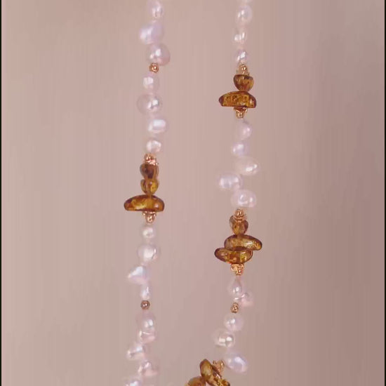 A cinematic video of the Cyra necklace in motion. As the piece moves, the light dances across the chatoyant Tiger's Eye and the iridescent baroque pearl, illustrating the dynamic, "living" energy of the natural materials.