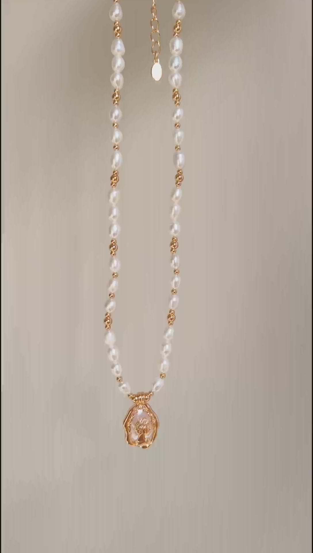 This cinematic video pans across the Elara necklace, capturing the shifting iridescence of the Mother-of-Pearl and the radiant glow of the pearl strand. The movement highlights the elegant drape of the 38cm chain and the shimmering details of the vintage medallion as it catches the light.