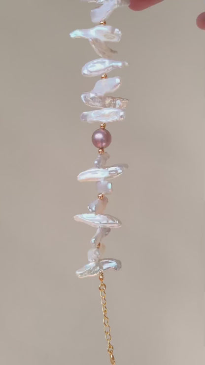 A 360-degree video showcase of the VÉRA LUSTRE Baroque Stick Pearl Bracelet, demonstrating the shimmering reflection of natural pearls under warm light.