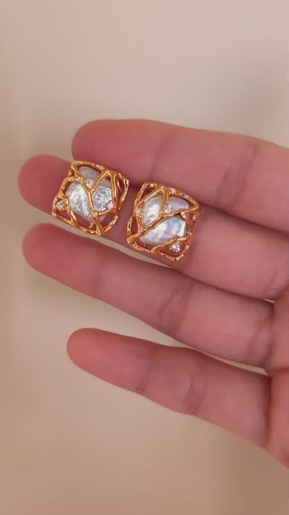 A detailed view of the Gaia earrings, demonstrating the 360-degree woven gold texture and the mesmerizing glow of the organic pearls.