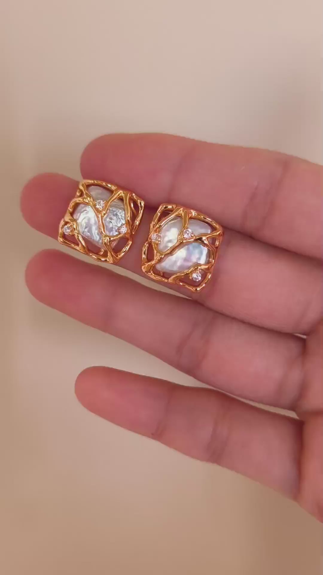 A detailed view of the Gaia earrings, demonstrating the 360-degree woven gold texture and the mesmerizing glow of the organic pearls.