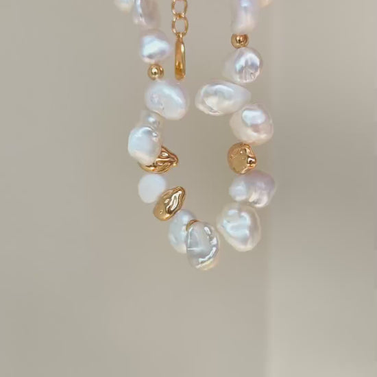 Close-up video frame of the Vera Lustre Ember bracelet, emphasizing the unique texture of 18K gold vermeil and natural iridescent pearls.