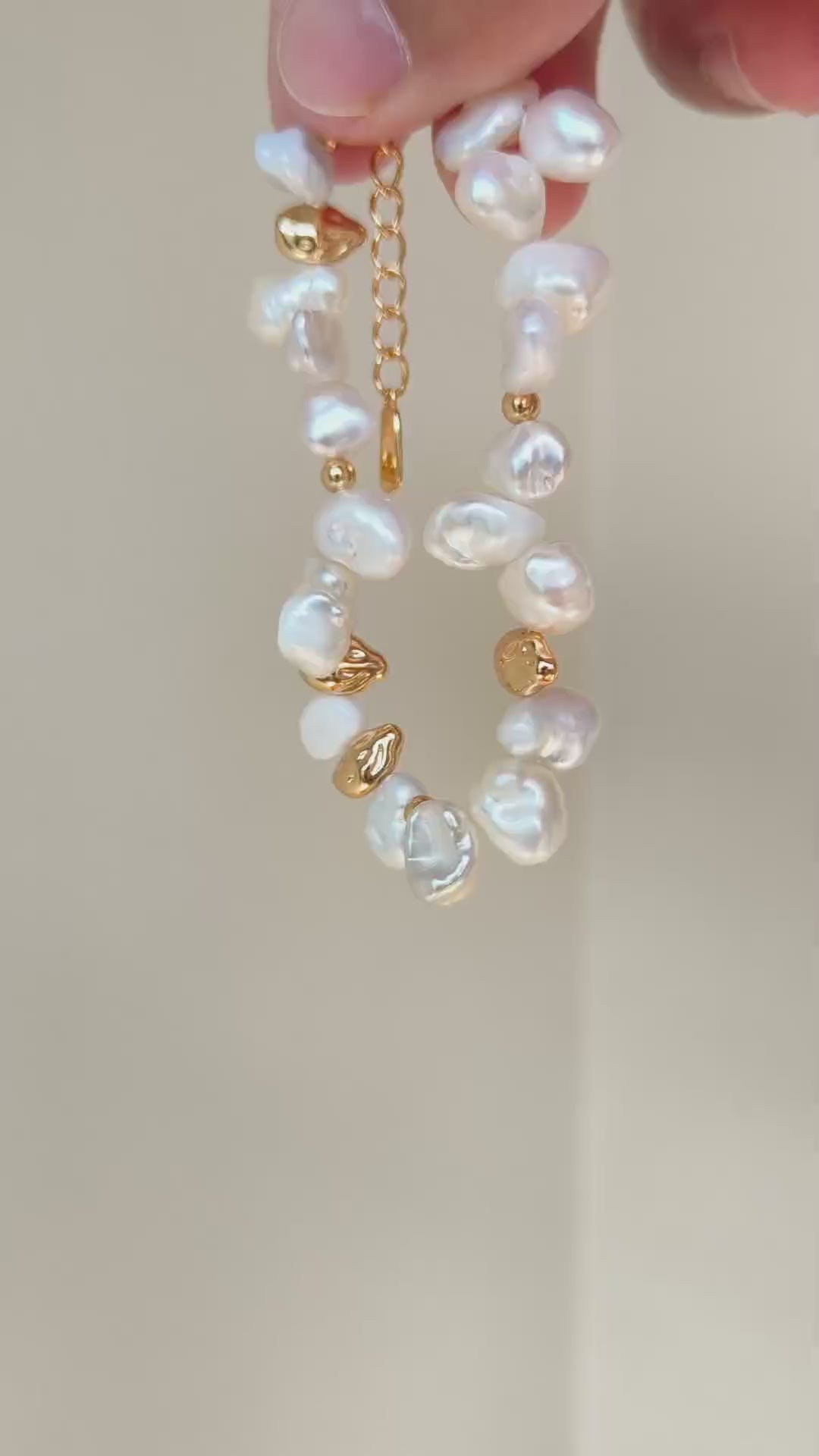 Close-up video frame of the Vera Lustre Ember bracelet, emphasizing the unique texture of 18K gold vermeil and natural iridescent pearls.