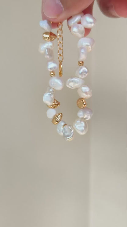 Close-up video frame of the Vera Lustre Ember bracelet, emphasizing the unique texture of 18K gold vermeil and natural iridescent pearls.