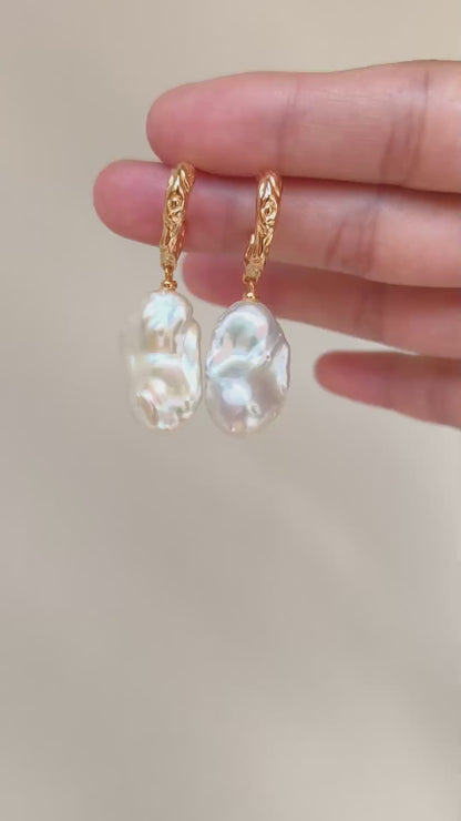 A cinematic video showing the Calliope earrings in motion. The footage captures the way the light dances across the uneven surfaces of the pearls, highlighting their natural iridescence and fluid movement.