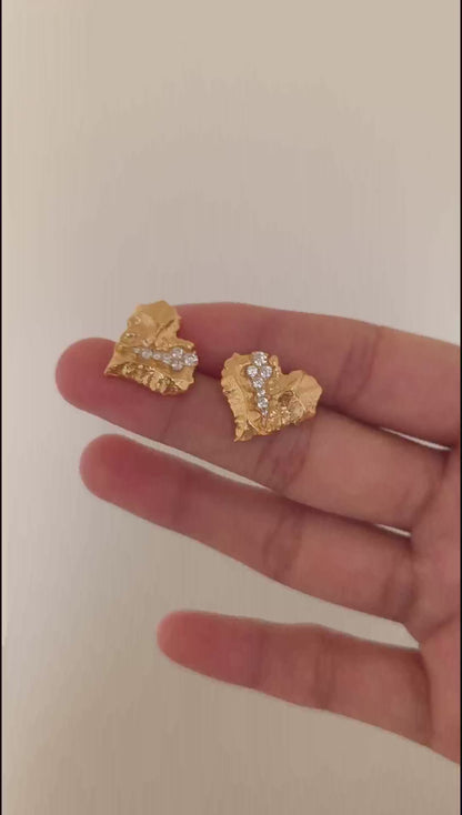 A cinematic video showing the Kardia earrings in motion. The footage captures the sparkle of the Cubic Zirconia nestled within the golden "cracks," demonstrating their intricate, light-catching detail.