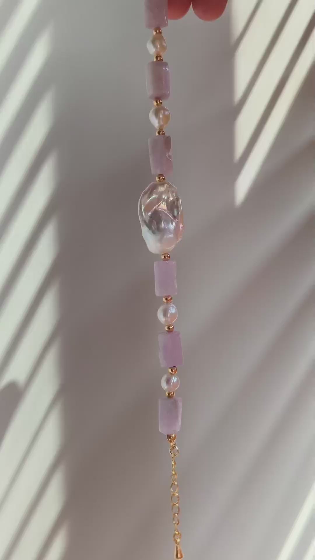 A cinematic video of the Liora bracelet in movement, showing the light dancing through the lavender crystals and reflecting off the satiny pearl surfaces.