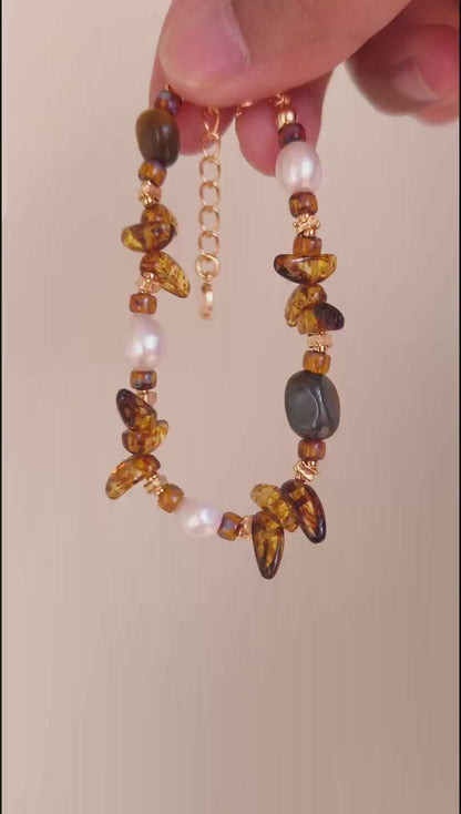 A cinematic video of the Cybele bracelet in movement. The footage captures the "cat-eye" effect of the Tiger's Eye and the shimmering light reflecting off the Czech glass and pearls.