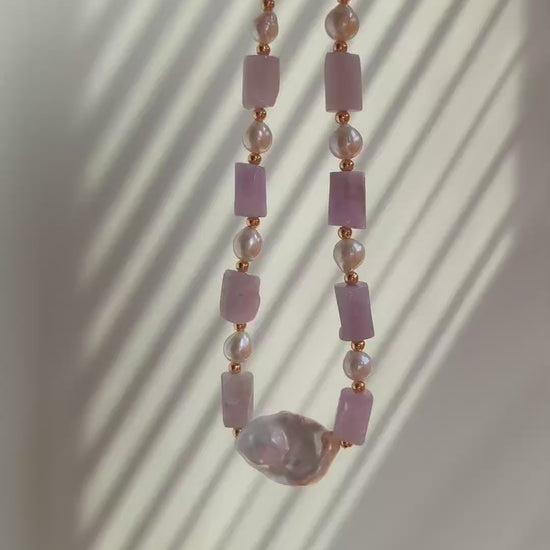 A cinematic video capturing the Amoris necklace in motion. As the light pans across, the lepidolite’s subtle shimmer and the baroque pearl's orient luster are beautifully showcased, illustrating the rhythmic and healing energy of the design.