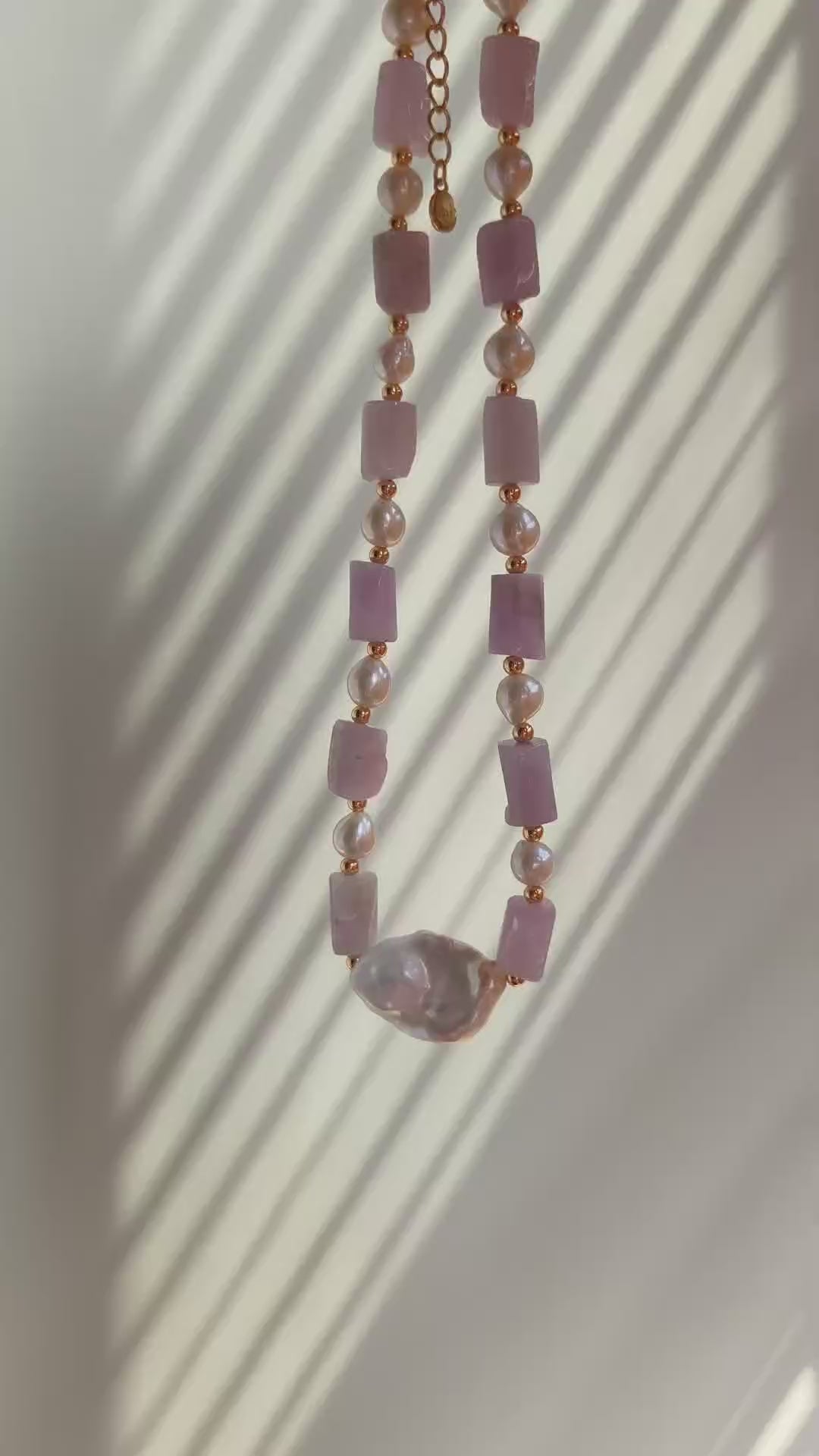 A cinematic video capturing the Amoris necklace in motion. As the light pans across, the lepidolite’s subtle shimmer and the baroque pearl's orient luster are beautifully showcased, illustrating the rhythmic and healing energy of the design.