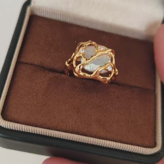 A close-up video of the Vera Lustre Terra ring being held, demonstrating the light reflection on the 18K gold vermeil and the natural pearl's glow.