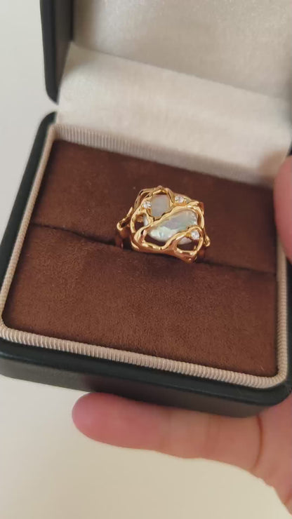 A close-up video of the Vera Lustre Terra ring being held, demonstrating the light reflection on the 18K gold vermeil and the natural pearl's glow.