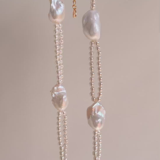 Vertical drape of the Selene double-layer statement necklace highlighting its unique tiered structure and light-catching luster.