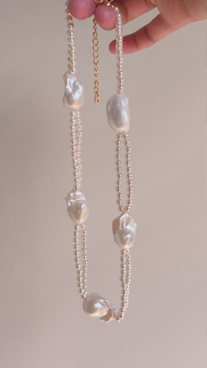 Vertical drape of the Selene double-layer statement necklace highlighting its unique tiered structure and light-catching luster.