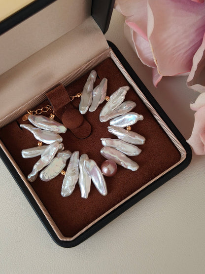 Baroque freshwater pearl bracelet with gold accents displayed in a luxury jewelry box, high lustre irregular pearls with pink accent pearl