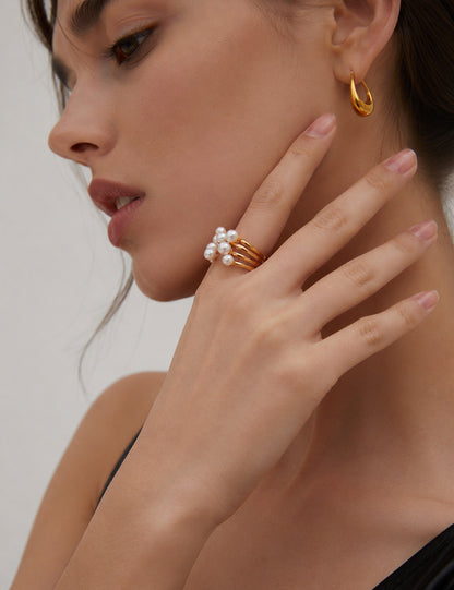 A professional studio shot of the Sia open ring in Vintage Gold, highlighting the warm 18K plating and the satiny luster of the central natural pearl.