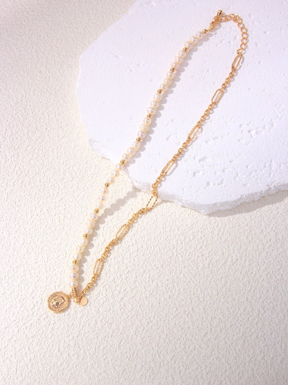 A high-resolution showcase of the Calyx asymmetric necklace resting on a white textured surface. The image highlights the seamless transition between a half-strand of creamy freshwater baroque pearls and a bold 18K gold vermeil link chain. This dual-texture design emphasizes the modern minimalist aesthetic, making it an ideal visual for customers seeking unique, handcrafted statement jewelry that blends organic and geometric elements.