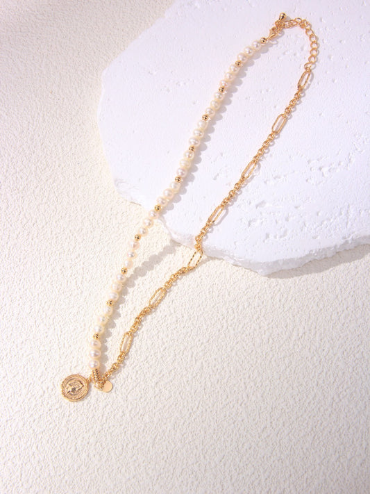 A high-resolution showcase of the Calyx asymmetric necklace resting on a white textured surface. The image highlights the seamless transition between a half-strand of creamy freshwater baroque pearls and a bold 18K gold vermeil link chain. This dual-texture design emphasizes the modern minimalist aesthetic, making it an ideal visual for customers seeking unique, handcrafted statement jewelry that blends organic and geometric elements.