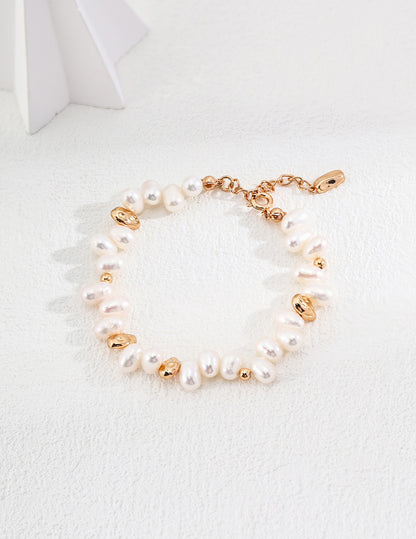 A professional studio shot of the Clémentine bracelet, highlighting the raw, non-uniform shapes of the natural pearls and the matching gold nugget accents.