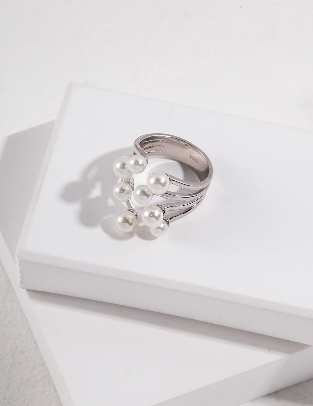 A high-contrast shot featuring both the gold and silver Sia rings side-by-side, illustrating the versatility of the mixed-metal collection for stacking or solo wear.