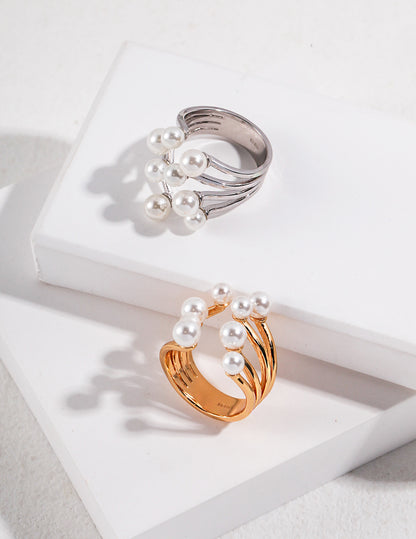 A lifestyle shot of the Sia pearl ring worn on the index finger, demonstrating its adjustable open-band fit and elegant, bypass sculptural silhouette.