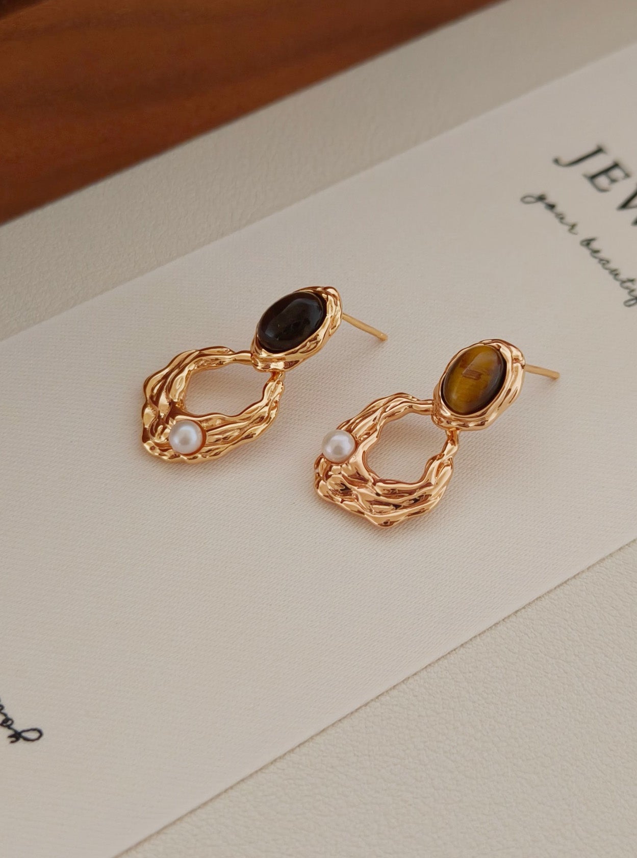 A macro shot focusing on the unique "cat's eye" effect (chatoyancy) of the Tiger's Eye stone, reinforcing the brand's commitment to authentic, high-grade gemstones.