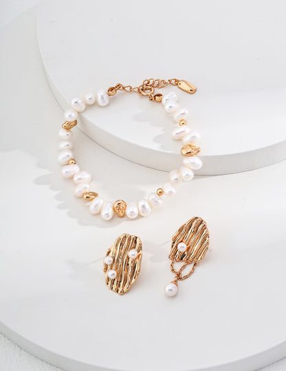 An overhead view of the bracelet and earrings laid flat, showing the rhythmic alternation between the lustrous pearls and the vintage gold hardware.