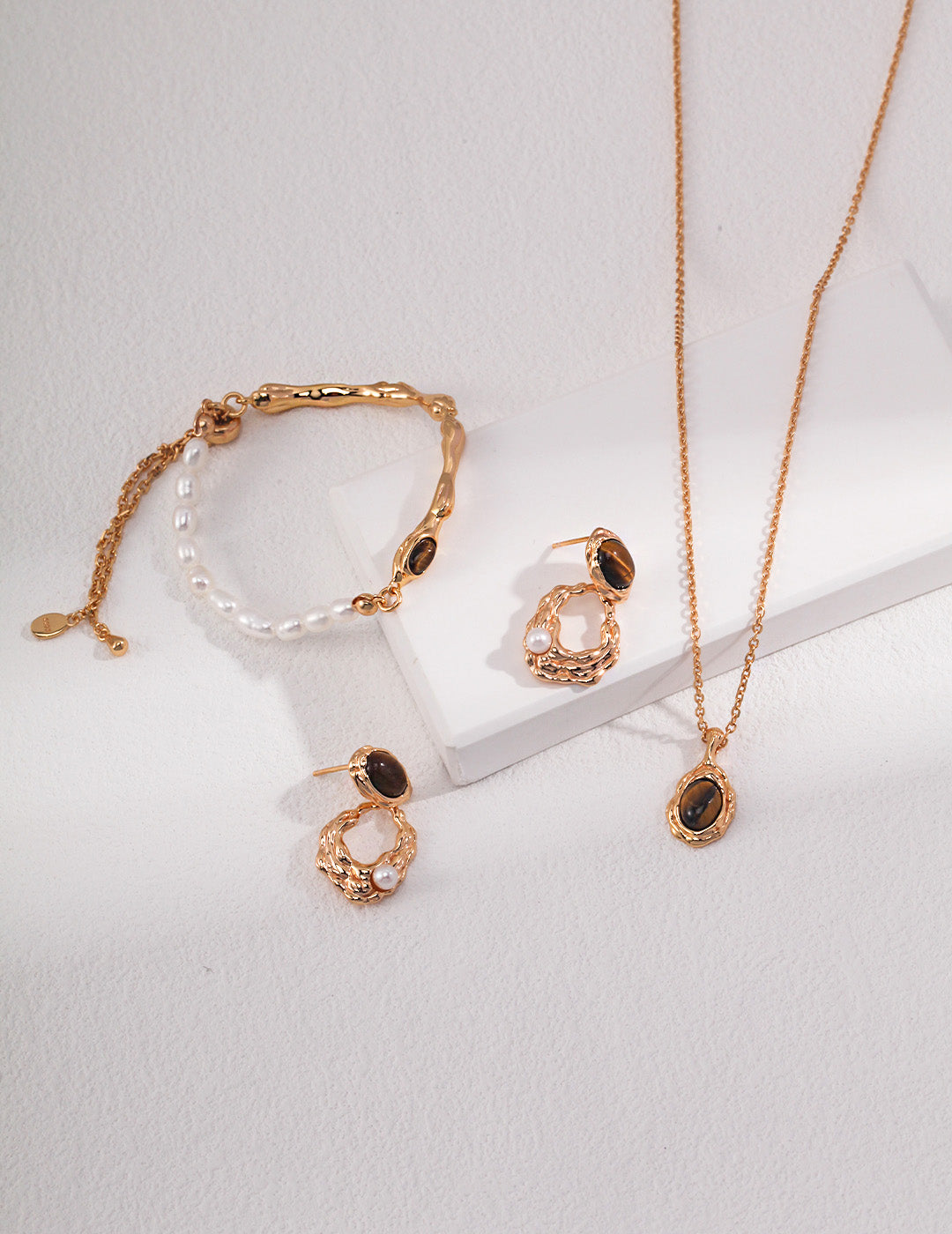 A curated display of the Gaia earrings alongside a matching Tiger's Eye pendant. This visual highlights a cohesive spiritual jewelry set, perfect for intentional gifting.
