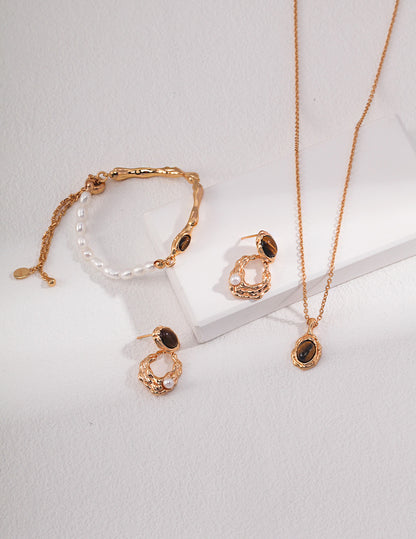 A curated display of the Gaia earrings alongside a matching Tiger's Eye pendant. This visual highlights a cohesive spiritual jewelry set, perfect for intentional gifting.