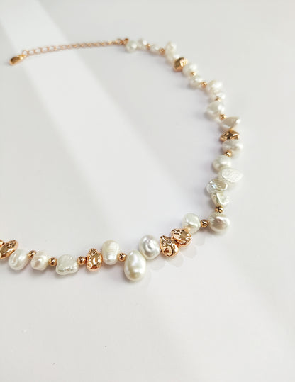 A macro close-up focusing on the unique, organic silhouettes of the natural freshwater pearls. The detail captures the mirror-like luster and the intricate, weathered textures of the vintage gold silver hardware, targeting customers who appreciate authentic, high-quality materials.