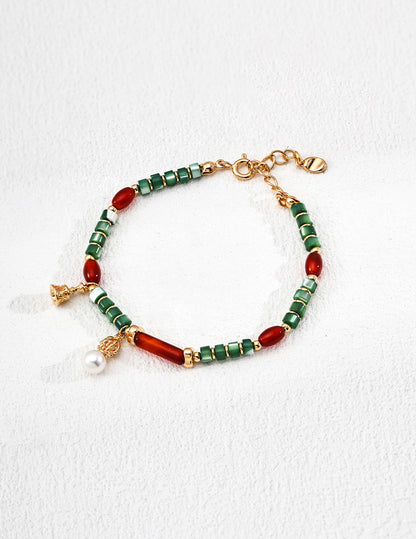 A clean studio photograph of the Iris bracelet, highlighting the eclectic mix of natural pearls, agate, and shell against the textured vintage gold links.